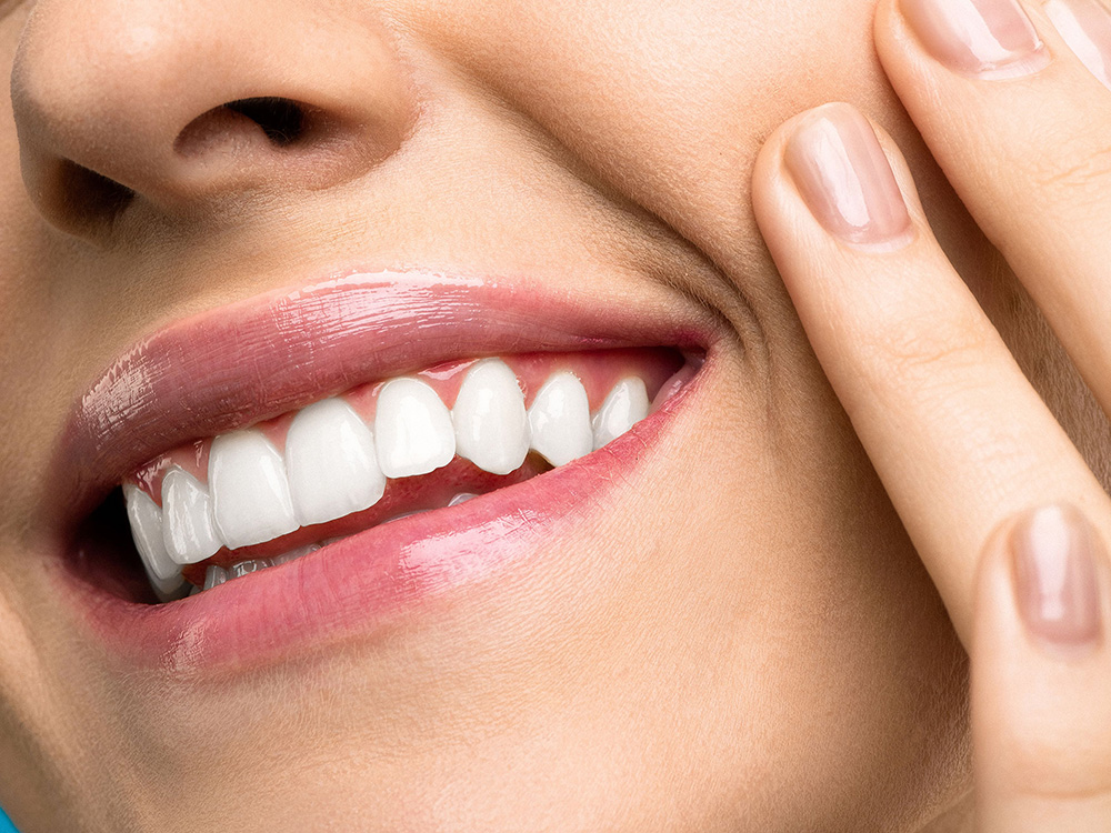 Image of a woman holding her face before root canal in Whittier CA by Uptown Dental Group.